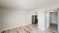 Located at 365 West Pierson Street in Phoenix, AZ, this single-floor, one-bedroom, one-bathroom unit delivers a clean, modern aesthetic throughout. Light wood-style plank flooring runs consistently across all rooms, complemented by bright white painted brick accent walls that add texture and character to the living spaces.

The combined dining and living area is an inviting, open space anchored by French doors that allow natural light to pour in and provide outdoor access. The well-appointed kitchen features gray shaker-style cabinetry, white quartz countertops, a subway tile backsplash, and a full suite of stainless steel appliances including a refrigerator, electric range, and dishwasher — offering a polished, functional cooking space.

The bedroom is cozy and efficiently laid out, featuring the same brick accent wall and a sliding-door closet for storage. Recessed lighting in select areas adds a refined touch throughout. The bathroom is clean and bright, with a white vanity topped with quartz, a tub-shower combination, and brushed nickel fixtures. A dedicated laundry area and hallway round out the layout. The unit also benefits from in-unit convenience features including a thermostat and ceiling ventilation. Overall, the space presents a fresh, well-renovated interior with consistent modern finishes.