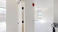 This thoughtfully designed 2-bedroom, 1-bathroom unit at 548 Central Ave, Unit 303, in Newark, NJ offers a clean, modern aesthetic throughout. Light gray wood-look flooring runs seamlessly across the entire space, creating a cohesive and airy feel. The kitchen is a standout feature, showcasing a two-tone design with high-gloss white upper cabinetry and warm wood-grain lower cabinets, granite-style countertops, a white subway tile backsplash, a black matte faucet, and stainless steel appliances including a gas range and refrigerator. The primary bedroom offers a comfortable footprint with ample closet storage, a wall-mounted mini-split HVAC unit, and large windows that welcome natural light. The second bedroom, accented by a stylish pendant light fixture, provides a bright, minimalist space. The bathroom is finished with large-format tile in both the shower and on the floor, complemented by matte black fixtures and a glass shower enclosure for a sleek, contemporary look. Clean white walls, panel-style interior doors with matte black hardware, and consistent modern finishes unify the space with a fresh, move-in-ready appeal.