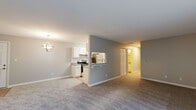 Located at 1700 Bayview Dr in Fort Wayne, Indiana, this well-appointed 2-bedroom, 2-bathroom residence offers a comfortable and functional single-floor layout. The open-concept living and dining area is finished with neutral-toned carpet and soft gray walls, creating a welcoming atmosphere. A globe chandelier adds a modern decorative touch overhead. The kitchen is a standout feature, designed in a galley style with crisp white cabinetry, granite countertops, subway tile backsplash, stainless steel appliances including a refrigerator and dishwasher, and light wood-style flooring. A pass-through window connects the kitchen to the living area, enhancing the open feel. The primary bedroom offers a generous footprint with carpeted flooring, access to a dedicated closet, and an en-suite bathroom complete with a tub-shower combo and granite vanity. The second bedroom features carpeted floors and a window allowing natural light. Both bathrooms are finished with granite countertops and light hardwood-style flooring. Each bedroom includes closet storage. The layout flows efficiently, with a hallway connecting all private spaces to the main living areas.