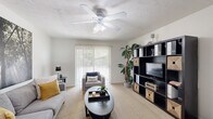 Located in Gainesville, FL, this single-floor, two-bedroom residence offers a well-organized layout designed for comfortable everyday living. The living room serves as the heart of the home, featuring plush carpeting, a ceiling fan, and a large sliding glass door dressed with vertical blinds that fills the space with natural light and provides views of the outdoors. The open, airy feel is complemented by neutral walls throughout.

The galley-style kitchen is equipped with warm wood cabinetry, tile flooring, a double sink, an electric range, dishwasher, and a full-size refrigerator, providing efficient use of space. Adjacent to the kitchen, the dining area offers room for a full dining set and includes a closet for additional storage.

Both bedrooms are carpeted and feature ceiling fans and windows with vertical blinds that invite natural light. The primary bedroom includes a spacious reach-in closet with bifold doors, offering ample storage. The second bedroom is similarly well-appointed and versatile.

Two bathrooms serve the residence — one with a tub-shower combination and white vanity cabinetry with tile flooring, and a second full bathroom also featuring a tub-shower combo and a clean, bright aesthetic. Together, these spaces make for a practical and inviting home in the heart of Gainesville.
