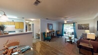 This thoughtfully designed two-bedroom, two-bathroom residence spans a single floor, offering a functional and comfortable layout throughout. The open living and dining area features hardwood-style flooring that transitions to plush carpet, crown molding, a ceiling fan, and a sliding glass door that fills the space with natural light and provides access to the outdoors. The galley-style kitchen is well-appointed with warm wood cabinetry, ample counter space, a full suite of appliances, and easy-care hard surface flooring. The primary bedroom is a restful retreat, featuring carpeted floors, a ceiling fan, and a window with outdoor views, while the second bedroom offers a similarly cozy atmosphere with soft carpet and natural light. Each bedroom is served by its own full bathroom. One bathroom features a tub-shower combination and warm wood vanity cabinetry, while the second bath includes a large vanity with an extended mirror and bright overhead lighting. Throughout the residence, textured ceilings, neutral wall tones, and consistent finishes create a cohesive and inviting ambiance. The overall layout is practical and livable, making efficient use of every square foot.