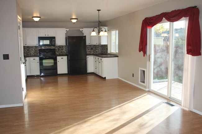 Sunny kitchen/dining/living area with doggie door and patio door to back deck and yard - 401 Prairie Avenue