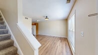 Located at 6121 Upper Hunters Trace in Louisville, KY, this two-story home offers a functional and comfortable layout across two floors. The main level welcomes you through a front door with an arched transom window, opening into a bright living room with warm wood-look vinyl flooring and a staircase leading to the upper level. The kitchen is well-equipped with rich oak cabinetry, dark countertops, white appliances including a refrigerator with ice maker, electric range, microwave, and dishwasher, complemented by a window that brings in natural light. A dedicated laundry room with wire shelving and washer/dryer hookups adds convenience on the main floor. The full bathroom features tile flooring, a wood-tone vanity, and a tub-shower combination. Upstairs, two carpeted bedrooms offer a cozy retreat, each with windows overlooking the outdoors. The primary bedroom includes a closet and ceiling fan, while the second bedroom features a double-door closet and its own ceiling fan. Neutral beige tones throughout create a cohesive, inviting atmosphere, and the layout makes efficient use of the home's overall footprint across both levels.