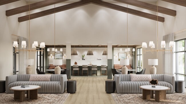 Spacious clubhouse with vaulted ceiling, pendant lights, lounge seating, and a communal kitchen with bar seating and décor - Oakwood Trails - A 62+ Community