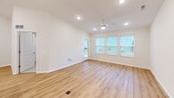 Located at 1352 Town Square Dr in Kent, Ohio, this well-appointed single-story home offers three bedrooms, two bathrooms, and a thoughtfully designed layout that maximizes everyday comfort. The entrance leads down a bright hallway with light wood-style flooring and recessed lighting, opening into a combined dining, kitchen, and living area. The kitchen is a standout feature, showcasing white shaker cabinetry, stainless steel appliances including a gas range, microwave, and French door refrigerator, a white countertop island with a built-in sink, and elegant pendant lighting overhead. The adjacent living room benefits from a ceiling fan, recessed lighting, and large windows that invite generous natural light, with a door providing direct access to the patio. The bedrooms feature plush carpet flooring and window treatments, with the primary bedroom offering a walk-in closet equipped with wire shelving. The bathrooms are finished with wood-look flooring, white vanities, and a tiled tub-shower combination. Six closets throughout the home provide ample storage. A dedicated laundry area, utility room, and an attached garage with an automatic opener round out the functional offerings of this clean, modern home.