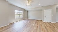 Located at 1200 Devils Glen Rd in Bettendorf, Iowa, this well-appointed three-story home offers four bedrooms, three bathrooms, and an attached garage. The entry-level garage features a clean concrete floor and interior access door, providing practical convenience. The main living floor showcases an open-concept kitchen and living area with light hardwood-style flooring, ceiling fans, and abundant natural light from large windows with outdoor views. The kitchen is outfitted with white shaker cabinetry, granite-look countertops, stainless steel appliances, and recessed lighting, flowing seamlessly into the living space. A carpeted staircase with a sleek black railing connects the floors. The bathrooms feature white vanities with clean countertops, black hardware accents, and wood-look tile flooring; one includes a tub-shower combo, while another offers a walk-in shower setup. The bedrooms are carpeted and bright, with vaulted or tray ceilings and windows framing outdoor greenery. The generously sized primary bedroom includes a walk-in closet with wire shelving. Neutral tones, modern fixtures, and consistent finishes throughout create a cohesive, move-in-ready aesthetic.
