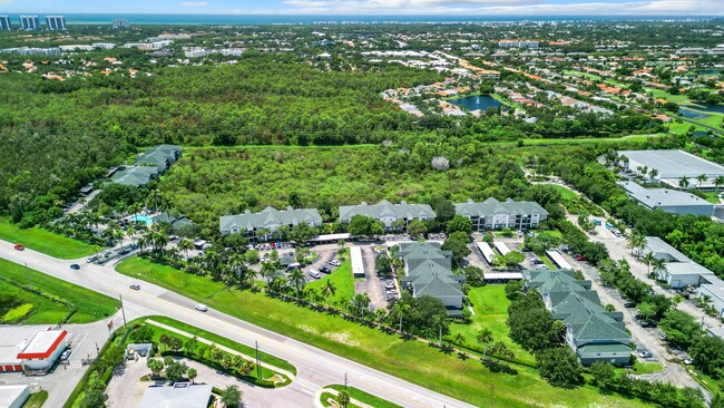 An expansive aerial view of our beautiful community, illustrating the balance of lush green surroundings and proximity to local amenities such as Barefoot Beach, making it an ideal place to call home. - Somerset Palms