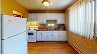 Located at 1630 Eustis St in Lauderdale, MN, this single-floor unit offers a practical and functional layout across several well-defined spaces. The living area is generously sized, featuring wall-to-wall carpeting, a baseboard heating system, and large windows with vertical blinds that allow ample natural light and views of the surrounding greenery. A wall-mounted air conditioning unit provides additional climate control comfort. The kitchen is efficiently designed with wood-look flooring, white cabinetry, dark laminate countertops, a built-in range and oven, and a full-size refrigerator. Under-cabinet lighting adds warmth to the cooking area, while a window with vertical blinds brings in natural light. The bedrooms are carpeted and offer clean, neutral walls with baseboard heating, providing a quiet and comfortable retreat. One bedroom features a wood-panel entry door, and another benefits from a sun-lit window with vertical blinds. The bathroom includes a full tub and shower combination with classic white tile accented by pink tile details, a pedestal-style vanity with mirror, and a clean, timeless aesthetic. Overall, the unit presents a straightforward, livable floor plan suited for everyday comfort.