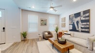 This two-story home is designed with a clean, modern aesthetic that prioritizes light, functionality, and comfort. The main living area features light wood-tone flooring, neutral walls, and a ceiling fan with recessed lighting, creating an inviting atmosphere. Large windows dressed with white blinds allow natural light to fill the space, complementing the warm, contemporary décor.

The kitchen is a standout feature, boasting white shaker cabinetry, light quartz countertops, a subway tile backsplash, and stainless steel appliances. A central island with bar seating provides both additional prep space and a casual dining option, making it a practical hub for daily living.

A half bath on the main level features a classic pedestal sink, matte black fixtures, and a large mirror. A dedicated laundry room with full-size washer and dryer adds everyday convenience.

The bedrooms are bright and carpeted, with ample natural light from well-placed windows. Each room includes generous closet space, including a large walk-in closet with full-length hanging storage. A full bathroom with white cabinetry, quartz counters, and matte black hardware serves the additional bedrooms. The overall ambiance is calm, cohesive, and move-in ready.