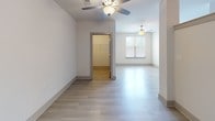 Located at 107 Knox Abbott Dr in Cayce, South Carolina, this single-floor unit offers a clean, modern design with a bright and open layout. Light-toned hardwood-style flooring flows throughout the main living areas, creating a cohesive and airy feel. Ceiling fans are installed in multiple rooms, ensuring comfortable airflow throughout the space.

The kitchen is well-appointed with white shaker-style cabinetry, granite countertops, a subway tile backsplash, a stainless steel undermount sink, and stainless steel appliances including a refrigerator, range, and microwave. A structural column subtly defines the transition between the kitchen and the open living area, which benefits from natural light through a window fitted with blinds.

The bathroom is finished with neutral tile flooring, a tub-shower combination with gray tile surround, white cabinetry with granite countertops, and a stacked washer and dryer unit conveniently integrated into the space — providing in-unit laundry. The overall color palette is light and neutral, with white walls and trim contributing to a clean, well-maintained aesthetic throughout. The floor plan is efficiently organized, making practical use of the available space.