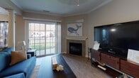 Located at 20 Dockside Pkwy in East Amherst, NY, this single-floor home offers a well-organized layout with a variety of functional spaces finished in warm, neutral tones throughout. The entryway features light tile flooring that transitions into hardwood-style flooring in the main living areas. The living room serves as the heart of the home, highlighted by a tile-surround fireplace, crown molding, and a sliding glass door that opens to an outdoor patio with green views. The kitchen is equipped with white cabinetry, granite-style countertops, stainless steel appliances, and tile flooring, flowing seamlessly into a dedicated dining area with hardwood-style floors and a window framed by decorative curtains. A versatile flex room with carpeted flooring and a window offers potential as a home office or additional bedroom. The primary bedroom is generously sized with plush carpet, a large window with outdoor views, and ample space for a full furniture suite. A second bedroom provides similar comfort and carpeted flooring. Two bathrooms serve the home: a full bathroom with a tub-shower combo, white vanity, and tile floors, and a half bathroom with matching tile and a clean, simple design. The home combines practical functionality with a comfortable, inviting ambiance throughout.