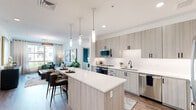 Located in Scottsdale, AZ, this well-appointed 2-bedroom, 2-bathroom residence offers a thoughtfully designed single-level layout. The open-concept kitchen is a standout feature, showcasing light wood-grain cabinetry with matte black hardware, quartz countertops, a central island with pendant lighting, and a full suite of stainless steel appliances including a French door refrigerator. Wood-look flooring flows throughout, tying the spaces together cohesively. The living room is bright and welcoming, with large windows that invite natural light and outdoor views. Both bedrooms are generously proportioned, each featuring ceiling fans, large windows with exterior views, and wood-look flooring. The primary bedroom benefits from its own dedicated closet with built-in shelving and hanging space. The bathrooms are finished in a clean, modern palette, with the full bath featuring a long double-sink vanity with matte black fixtures and a shower-tub combination. Hallways connect the rooms efficiently, maintaining a smooth flow throughout the residence. The overall aesthetic is contemporary and neutral, with clean lines and quality finishes that characterize this Scottsdale home.