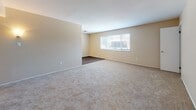 Located at 414 Turlington Rd in Newport News, Virginia, this single-story unit offers a straightforward and functional layout spread across several well-defined rooms. The living area is generously sized, finished with neutral-toned carpet and warm beige walls, and receives natural light through a window fitted with blinds, lending a bright and open feel to the space. The bedrooms continue the same carpeted flooring and neutral color palette, each offering a comfortable footprint. One bedroom features a walk-in closet, providing ample storage, while additional closet space is present throughout. The kitchen is equipped with white cabinetry, dark countertops, a stainless sink, and wood-look plank flooring that adds a warm contrast to the light walls. Black appliances, including a refrigerator and range, complete the kitchen setup. The bathroom features a full tub and shower combination with clean white tile surround, chrome fixtures, and dark wood-look flooring that ties in with the rest of the unit. Ceiling-mounted lighting and HVAC vents are consistently present throughout, ensuring comfort and practicality. The overall ambiance is clean, neutral, and move-in ready, making this Newport News unit a solid and functional living space.