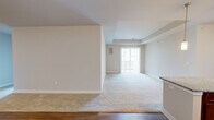 This well-appointed single-story home offers four bedrooms, two bathrooms, and a thoughtfully designed layout that maximizes comfort and functionality. The open-concept living and dining area is a standout feature, showcasing a seamless transition between hardwood-style flooring near the entry and plush carpeting throughout the main living space. A tray ceiling adds architectural interest, while a sliding glass door at the far end of the room invites natural light and provides access to the outdoors.

The kitchen is both stylish and practical, featuring rich warm-toned cabinetry, granite countertops, and stainless steel appliances including a range, over-the-range microwave, and refrigerator. Light wood-style flooring ties the space together with a clean, modern feel.

The four bedrooms are generously sized, each finished with soft carpeting and neutral tones. The primary bedroom benefits from a tray ceiling detail and a large window that fills the room with natural light. Additional bedrooms offer similar comfort with windows and ample space. Two closets provide convenient storage throughout the home.

The bathrooms are finished with granite-topped vanities, tile flooring, and glass-enclosed showers, reflecting a consistent level of quality throughout. Clean lines, neutral palettes, and practical finishes make this home a versatile and move-in ready space.