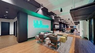 The Victor's community space in St. Louis, MO, is a thoughtfully designed, expansive gathering hub that blends contemporary style with industrial charm. The centerpiece of the main lounge is a bold teal neon "Live Victoriously" sign that anchors a curated seating area featuring mid-century modern furniture, layered area rugs, and eclectic accent pieces that encourage relaxed socializing. Soaring ceilings with exposed ductwork and pendant lighting lend an open, airy feel throughout.

A bright, café-style dining area offers an abundance of bistro tables and mixed seating arrangements, bathed in natural light from oversized black-framed windows. These windows also frame views of and provide direct access to an inviting outdoor courtyard, adorned with string lights and additional seating for alfresco gatherings.

A dedicated screening room delivers an intimate entertainment experience, featuring plush black leather seating and a cozy interior lounge with leather sofas, plaid-accented walls, and warm pendant lighting. The fully appointed demonstration kitchen is outfitted with rich wood cabinetry, a large stone-topped island with bar seating, professional-grade appliances, and globe pendant lights — ideal for cooking events and community gatherings. Together, these spaces offer residents a dynamic and versatile environment for connection and community.