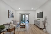 Located at 7187 Citrus Ave in Fontana, California, this single-story residence offers a clean, contemporary design highlighted by light wood-tone flooring that flows consistently throughout the entire space, creating a cohesive and airy atmosphere.

The open-concept living area is bright and welcoming, featuring recessed lighting and crisp white walls. Sliding glass doors lead directly to a private outdoor patio, allowing natural light to fill the room and providing a seamless indoor-outdoor connection. The space comfortably accommodates both a seating and dining arrangement.

The kitchen is well-appointed with modern two-tone cabinetry in a warm taupe finish, light quartz countertops, and a full suite of stainless steel appliances, including a range, over-the-range microwave, dishwasher, and refrigerator. A movable kitchen island provides additional prep and storage space.

The bedrooms are calm and restful, each featuring neutral walls, natural light from window treatments, and ample closet space with mirrored sliding doors. The bathroom is finished with marble-style tile surrounds in the shower-tub combination, chrome fixtures, light wood cabinetry, and consistent wood-tone flooring, lending the space a polished, spa-like quality throughout.