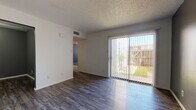 Located at 3510 Wildewood Dr in San Angelo, Texas, this single-floor unit offers a practical and straightforward layout across several distinct living areas. The entryway welcomes you with warm wood-look plank flooring and clean white walls, setting a neutral tone throughout the common spaces.

The living area is bright and open, featuring durable wood-look flooring and a textured ceiling. A full-width sliding glass door with vertical blinds fills the space with natural light and provides direct access to an enclosed outdoor patio, offering views of the surrounding greenery and fencing.

The kitchen is efficiently designed with dark wood cabinetry, light laminate countertops, and a pass-through counter that connects to the adjacent living and dining areas. White appliances, including a refrigerator and electric range, complete the functional setup. Wood-look flooring continues throughout the kitchen.

The bedrooms feature wall-to-wall carpet and are accented with bold gray-blue accent walls, adding a touch of character. Each bedroom includes access to closet space, providing practical storage. The bathroom is clean and straightforward, featuring a tiled tub-shower combination, a vanity with light countertops and white cabinetry, and wood-look flooring. A hallway connects the private areas of the unit, finished with carpet and textured ceilings consistent with the rest of the home.