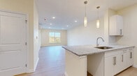 This well-appointed one-bedroom, one-bathroom residence in Branford, Connecticut offers a thoughtfully designed single-floor layout that maximizes both function and comfort. The open-concept living, dining, and kitchen area serves as the heart of the home, featuring light hardwood-style flooring, recessed lighting, and a large window that frames pleasant outdoor views and fills the space with natural light. The kitchen stands out with granite countertops, a peninsula with a built-in sink, white cabinetry, and elegant pendant lighting — all contributing to a clean, modern aesthetic. A dedicated dining area flows seamlessly into the living space, creating an ideal environment for both daily living and entertaining. The bedroom is a comfortable, well-sized retreat with its own large window offering scenic views, a wall-mounted mini-split system for climate control, and recessed lighting. The bathroom features tile flooring, a walk-in shower with white subway tile, and a vanity. Additional practical amenities include a dedicated laundry room, a utility room, two closets, and a hallway that connects the spaces efficiently. Throughout the residence, warm neutral tones, consistent flooring, and bright finishes create a cohesive and inviting atmosphere.