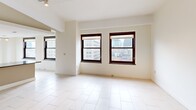 Located at 10 Witherell St in the heart of downtown Detroit, this 2-bedroom, 1-bathroom residence offers a well-designed single-floor layout. The open-concept living and dining area is bright and spacious, featuring large dark-framed windows that frame views of the surrounding Detroit cityscape and fill the space with natural light. Light-toned tile flooring runs throughout the main living areas, complementing the clean, neutral color palette.

The kitchen is well-appointed with light wood cabinetry, dark granite countertops, stainless steel appliances including a refrigerator, electric range, microwave, and dishwasher, and a peninsula that connects seamlessly to the living and dining space. Track and pendant lighting add functional illumination throughout.

Both bedrooms feature plush carpeting and are served by a hallway with three closets for ample storage. The primary bedroom is generously sized with a double-door closet and wall sconce lighting. The second bedroom features a window with city views. A dedicated laundry area with an in-unit washer is conveniently accessible from the bedroom hall. The bathroom is finished with tile flooring and includes accessibility-friendly grab bars. This residence also includes a hallway connecting all rooms for a functional and cohesive floor plan.
