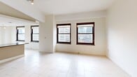 Located at 10 Witherell St in the heart of downtown Detroit, this 2-bedroom, 1-bathroom residence offers a well-designed single-floor layout. The open-concept living and dining area is bright and spacious, featuring large dark-framed windows that frame views of the surrounding Detroit cityscape and fill the space with natural light. Light-toned tile flooring runs throughout the main living areas, complementing the clean, neutral color palette.

The kitchen is well-appointed with light wood cabinetry, dark granite countertops, stainless steel appliances including a refrigerator, electric range, microwave, and dishwasher, and a peninsula that connects seamlessly to the living and dining space. Track and pendant lighting add functional illumination throughout.

Both bedrooms feature plush carpeting and are served by a hallway with three closets for ample storage. The primary bedroom is generously sized with a double-door closet and wall sconce lighting. The second bedroom features a window with city views. A dedicated laundry area with an in-unit washer is conveniently accessible from the bedroom hall. The bathroom is finished with tile flooring and includes accessibility-friendly grab bars. This residence also includes a hallway connecting all rooms for a functional and cohesive floor plan.