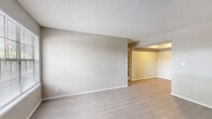 Located at 2842 E 51st St in Tulsa, Oklahoma, this two-bedroom, one-bathroom single-floor unit offers a well-organized layout across a comfortable footprint. The living room serves as the heart of the home, featuring light wood-look flooring, a striking tile-surround fireplace, and a large window that fills the space with natural light. The kitchen connects seamlessly to the living area via an open breakfast bar, and includes warm wood cabinetry, a gas range, refrigerator, and ample overhead storage. The layout flows through a hallway connecting the living spaces to the private areas of the home. Both bedrooms are carpeted and finished with neutral tones; the primary bedroom is a well-proportioned room accompanied by a dedicated walk-in closet outfitted with multiple wire shelving units for organized storage. The second bedroom also features a window with natural light and direct access to the hallway. The full bathroom includes a tiled tub-shower combination and clean white fixtures. A dedicated laundry area adds everyday convenience. Textured ceilings are found throughout, maintaining a consistent aesthetic. The unit also includes two closets total, providing practical storage solutions throughout the home.