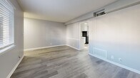 Located at 2572 Lenox Rd NE in Atlanta, GA, this one-bedroom, one-bathroom unit offers a clean, modern aesthetic across a thoughtfully arranged single-floor layout. Consistent gray-toned hardwood-style flooring runs throughout the entire space, creating a cohesive and contemporary look.

The living room is open and well-lit, featuring soft gray walls and white trim that give the space a bright, neutral character. It connects seamlessly to the combined dining and kitchen area, which is outfitted with white shaker-style cabinetry, granite-look countertops, a black range with overhead ventilation, a black refrigerator, and a single-basin sink — all complemented by natural light streaming through a window adjacent to the entry door.

The bedroom is generously proportioned, featuring a large built-in closet with sliding doors, natural light from a window with blinds, and the same gray flooring found throughout. Additional storage is provided by multiple closets distributed across the unit.

The bathroom includes a full-size soaking tub with an overhead shower, white subway tile surround, and classic chrome fixtures.

The entrance provides a welcoming transition into the space, with natural light filtering in from multiple windows. Overall, the unit presents a clean, move-in-ready environment with practical storage solutions in a well-connected Atlanta location.