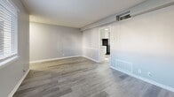Located at 2572 Lenox Rd NE in Atlanta, GA, this one-bedroom, one-bathroom unit offers a clean, modern aesthetic across a thoughtfully arranged single-floor layout. Consistent gray-toned hardwood-style flooring runs throughout the entire space, creating a cohesive and contemporary look.

The living room is open and well-lit, featuring soft gray walls and white trim that give the space a bright, neutral character. It connects seamlessly to the combined dining and kitchen area, which is outfitted with white shaker-style cabinetry, granite-look countertops, a black range with overhead ventilation, a black refrigerator, and a single-basin sink — all complemented by natural light streaming through a window adjacent to the entry door.

The bedroom is generously proportioned, featuring a large built-in closet with sliding doors, natural light from a window with blinds, and the same gray flooring found throughout. Additional storage is provided by multiple closets distributed across the unit.

The bathroom includes a full-size soaking tub with an overhead shower, white subway tile surround, and classic chrome fixtures.

The entrance provides a welcoming transition into the space, with natural light filtering in from multiple windows. Overall, the unit presents a clean, move-in-ready environment with practical storage solutions in a well-connected Atlanta location.