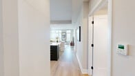 This well-appointed 2-bedroom, 2-bathroom residence in Bethesda, MD offers a thoughtfully designed single-floor layout with modern finishes and an abundance of natural light. The open-concept living and kitchen area serves as the heart of the home, anchored by soaring windows that frame sweeping panoramic views of the Bethesda skyline and access to a private balcony. Light hardwood flooring flows throughout, complementing the neutral palette.

The kitchen features two-tone cabinetry — dark lower cabinets contrasted by crisp white uppers — paired with white quartz countertops, a geometric herringbone tile backsplash, and stainless steel appliances including an LG range and built-in microwave.

The primary bedroom is generously proportioned, bathed in natural light from floor-to-ceiling windows and a glass balcony door offering expansive views. The second bedroom is a comfortable retreat with soft lighting and ample closet space. In total, four closets provide excellent storage throughout the residence.

Both bathrooms showcase marble-look tile flooring, dark cabinetry with gold hardware, and clean white countertops. The primary bath features a glass-enclosed walk-in shower, while the second bathroom offers a full soaking tub. An in-unit laundry completes the practical layout of this refined Bethesda residence.