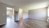 Located at 110 E Baseline Rd in San Dimas, CA, this well-appointed one-bedroom, one-bathroom unit offers a thoughtfully organized single-floor layout. Throughout the main living areas and kitchen, durable wood-look flooring adds a clean, modern feel, while textured ceilings lend a classic character to each room.

The living room is a bright, open space with neutral wall tones and generous floor area, providing a welcoming environment for everyday living. A wall-mounted AC unit ensures year-round climate control.

The galley-style kitchen is a functional highlight, featuring crisp white shaker cabinetry, light quartz-style countertops, a stainless steel sink, and a black gas range. A skylight panel above brightens the workspace, and a ceiling fan with light fixture adds comfort. A sliding glass door at the end of the kitchen opens to an outdoor area with views of surrounding greenery.

The bedroom offers a cozy retreat with plush wall-to-wall carpeting, soft neutral walls, and a window with vertical blinds allowing natural light. The panel-style closet door provides practical storage.

The bathroom is clean and straightforward, featuring a full shower/tub combo with bright white surrounds and standard fixtures. The unit's cohesive neutral palette and updated finishes create a comfortable, move-in-ready atmosphere throughout.