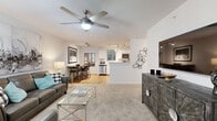 Located in Katy, TX, this well-designed one-bedroom, one-bathroom unit offers a smart and functional layout across a single floor. The open-concept kitchen and living area serves as the heart of the home, where warm wood-look flooring flows throughout. The kitchen is equipped with white cabinetry, light countertops, stainless steel appliances including a refrigerator, range, microwave, and dishwasher, plus a built-in open shelving nook that provides additional storage and display space. A dining area with track lighting sits adjacent to the kitchen, creating a seamless transition for everyday living and entertaining. The living room features plush carpet, a ceiling fan with light fixture, and a large window dressed with sheer curtains that fill the space with natural light. The bedroom is a comfortable retreat with soft carpet, a generously sized window with blinds and curtains, and ample room for a king-sized bed. The full bathroom includes a shower-tub combo with a curtain, wood-look flooring, and clean white walls. Throughout the unit, a neutral color palette and consistent finishes create a cohesive and inviting atmosphere.