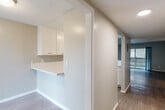 Located on W Linden St in Riverside, CA, this single-story 2-bedroom, 2-bathroom unit offers a practical and comfortable layout across a well-utilized floor plan. Wood-look flooring runs throughout the main living areas, complemented by neutral wall tones and textured ceilings that give the space a clean, consistent aesthetic.

The kitchen is a standout feature, showcasing bright white cabinetry, light quartz countertops, an undermount sink, and a gas range. A pass-through counter connects the kitchen to the dining area, enhancing the open flow between spaces. A built-in overhead cabinet with a lower desk-height counter provides additional functionality near the dining area.

The spacious living room features a wall-mounted A/C unit and a sliding glass door that opens directly to a private patio, bringing in natural light and outdoor access. A hallway leads to both bedrooms, each with wood-look flooring and easy access to closet storage. The primary bedroom is generously sized and includes a ceiling fan. The two bathrooms are finished with white tile — one featuring a tub-shower combination and the other a walk-in shower. A utility room and multiple closets round out the home's practical storage offerings.