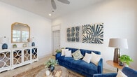 Located at 33455 Buckshot Ln in Magnolia, TX, this single-story home offers a thoughtfully designed layout with clean, modern finishes and a warm, welcoming ambiance. The welcoming entryway features polished concrete floors, elevated ceilings, and abundant recessed lighting, setting an airy tone carried throughout the home. The open-concept kitchen is a standout, showcasing white shaker cabinetry, quartz countertops, stainless steel appliances, a subway tile backsplash, and a generously sized center island with pendant lighting and seating — ideal for both cooking and casual dining. A dedicated dining area accommodates a full-sized table beneath an elegant chandelier. The living room offers generous ceiling height, a ceiling fan, and access to the entry foyer. Bedrooms provide comfortable retreats, with natural light streaming through large windows. The primary suite connects to a long, well-appointed en-suite bathroom featuring an extended dual-sink vanity with quartz countertops and a soaking tub. A secondary bathroom mirrors the home's neutral palette with gray cabinetry and light wood-look flooring. Throughout, the home maintains a cohesive aesthetic of light, neutral tones paired with modern fixtures, creating a bright and inviting atmosphere.