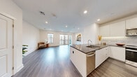 Located at 95 Maple St in Stoneham, MA, this well-appointed 2-bedroom, 2-bathroom residence offers a thoughtfully designed open-concept floor plan with contemporary finishes throughout. Wide-plank hardwood flooring flows seamlessly across the entire living space, anchoring a bright and cohesive interior.

The combined kitchen and living area serves as the heart of the home. The modern kitchen features sleek white flat-front cabinetry extending to the ceiling, a marble-style backsplash, dark granite countertops, stainless steel appliances, and a central island with a built-in sink — ideal for both cooking and entertaining. The living area opens to a private balcony through sliding glass doors, allowing abundant natural light to fill the space. A built-in shelving unit provides an elegant display area.

The spacious primary bedroom includes a ceiling fan, natural light from large windows, and access to generous closet space featuring wire-shelving systems. The second bedroom also includes a ceiling fan and ample natural light. Both bedrooms are well-proportioned and versatile.

The primary bathroom is finished with a dual-sink vanity, dark stone countertops, modern fixtures, and marble-tiled shower walls. Additional conveniences include five closets, in-unit laundry, and recessed lighting throughout.