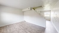 Located at 5104 Dandy Ct in Virginia Beach, Virginia, this two-story home offers a practical and well-organized layout spread evenly across two floors. The main level features a bright living room with light wood-tone flooring and a staircase leading to the upper level, as well as a separate dining room and a kitchen equipped with white shaker-style cabinetry, granite-look countertops, a stainless steel sink, and black appliances including a refrigerator and electric range. Natural light filters in through windows with blinds throughout the home. Upstairs, two carpeted bedrooms provide comfortable retreats, with the spacious primary bedroom offering generous square footage and ample closet space, including a louvered double-door closet. The second bedroom is similarly carpeted with a window and its own closet. The full bathroom on the upper level features a tiled tub-shower combination and a window with an outdoor view. Multiple closets throughout the home provide excellent storage. The neutral color palette, updated finishes in the kitchen, and consistent flooring choices across both levels contribute to a clean, move-in-ready aesthetic throughout the property.