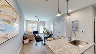 Located at 7600 Heron Cir in Vero Beach, Florida, this thoughtfully designed 2-bedroom, 1-bathroom residence offers a comfortable and modern living experience across a single floor. The open-concept kitchen and living area serves as the heart of the home, where the kitchen impresses with crisp white shaker cabinetry, granite countertops, a classic subway tile backsplash, stainless steel appliances, and a central island with pendant lighting — ideal for both cooking and entertaining. Light wood-style flooring flows throughout the main living areas, adding warmth and continuity. The living room is bright and welcoming, featuring large windows that allow abundant natural light, a ceiling fan, and direct access to the outdoors. Both bedrooms are carpeted for comfort and feature ceiling fans, generous windows, and tasteful accent walls in soothing coastal tones. The primary bedroom offers a comfortable, well-proportioned retreat. The bathroom is finished with granite countertops, white cabinetry, a large vanity mirror, and wood-style flooring, with a dedicated walk-in closet providing excellent storage. A connecting hallway with additional closet space enhances the home's functional layout. Neutral, contemporary color palettes and consistent quality finishes throughout give this residence a polished, cohesive feel.