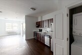 Located at 747 Grand St in Jersey City, NJ, this one-bedroom, one-bathroom residence offers a well-designed single-floor layout with a practical and modern finish throughout. Rich hardwood flooring flows consistently across the living areas and bedroom, creating a warm and cohesive aesthetic.

The kitchen is a standout feature, outfitted with deep mahogany-toned cabinetry, white quartz countertops, a classic subway tile backsplash, and a full suite of stainless steel appliances including a refrigerator, dishwasher, electric range, and under-cabinet range hood. A dedicated laundry closet with a stacked washer and dryer unit adds significant convenience.

The living area is open and bright, with clean white walls and ample space for comfortable furnishing arrangements. The bedroom is generously proportioned, offering a quiet retreat with a window providing views of the surrounding neighborhood streetscape and a wall-mounted HVAC unit for climate control.

The bathroom includes a full soaking tub with a subway-tiled shower surround, complemented by classic fixtures. Throughout the unit, white panel doors and crisp trim work contribute to a clean, contemporary feel, making this a functional and well-appointed residence in Jersey City.