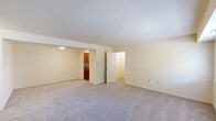 Located at 1813 Summit St in Lebanon, Pennsylvania, this single-floor unit offers a practical and comfortable layout designed for everyday living. The spacious living area is finished with soft wall-to-wall carpeting and features a large window that fills the room with natural light and provides views of the surrounding greenery. The layout flows conveniently toward a kitchen equipped with warm wood cabinetry and appliances, offering functional workspace for meal preparation. Multiple carpeted bedrooms provide comfortable retreats, each with windows that bring in natural light and outdoor views. Several bedrooms include closets with built-in shelving for organized storage. The unit includes two bathrooms: one features a full tub-shower combination with tiled surround and wood-look flooring, while the second offers a stand-alone shower unit with integrated corner shelving. A dedicated laundry room houses a full-size washer and dryer, complemented by overhead wire shelving for added storage convenience. Throughout the unit, neutral cream-toned walls and consistent flooring choices create a cohesive and understated aesthetic. A hallway connects the private areas of the unit, enhancing the overall sense of a well-organized and functional floor plan suited for a range of living needs.