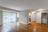 This single-floor residence offers a cohesive and practical layout designed for comfortable everyday living. The open living area is a standout feature, showcasing warm hardwood-style flooring that extends throughout the main spaces, neutral beige walls, and a large sliding glass door flanked by vertical blinds that floods the room with natural light and provides outdoor views. The space flows seamlessly toward the kitchen and private hallway.

The kitchen is well-equipped with honey-toned wood cabinetry, granite countertops, tile flooring, and a full suite of stainless steel appliances including a refrigerator, electric range, built-in microwave, and dishwasher. A window above the counter brings in additional natural light.

The bedrooms are carpeted and neutral in tone, each offering a calm and restful atmosphere. One bedroom features a mirrored sliding-door closet, while another includes a window with blinds overlooking greenery outside.

The bathroom is finished with tile flooring, a granite-topped vanity with wood cabinetry, and a full tub-shower combination. Throughout the unit, white trim and consistent warm-toned walls create a unified and inviting aesthetic.