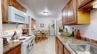 Located in Westlake, Ohio, this single-floor, 2-bedroom, 2-bathroom residence offers a thoughtfully designed layout with comfortable living spaces throughout. The living room is highlighted by large sliding glass doors that invite abundant natural light and provide views of the outdoors, with plush carpeting and a textured ceiling adding warmth to the space. Adjacent to the living room, the dining area features a ceiling fan, chair rail molding, and continued access to the sliding glass doors, creating a seamless connection between the two spaces. The galley-style kitchen is equipped with warm wood cabinetry, granite-style countertops, white appliances including a range, microwave, and refrigerator, and easy-care flooring. A dedicated laundry room houses a full-size washer and dryer with overhead shelving for added storage. The spacious primary bedroom offers generous proportions with soft carpeting and neutral walls. The second bedroom provides flexible use as a guest room or home office. Both bathrooms are finished with tile flooring, wood vanities, and well-lit mirrors. The overall ambiance is bright, clean, and move-in ready, offering a practical and comfortable living environment.