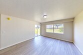 Located at 4600 E Moody Blvd in Bunnell, Florida, this 2-bedroom, 2-bathroom single-story residence offers a functional and comfortable layout designed for everyday living. Light-toned laminate flooring flows throughout the main living areas and bedrooms, creating a clean, cohesive aesthetic across the home.

The combined kitchen and living room serves as the heart of the space. The kitchen features warm wood-toned cabinetry, light countertops, a double-basin sink set into a peninsula, a white range, and a full-size refrigerator. Tile flooring grounds the kitchen area, which opens seamlessly toward the living room. The living room is bright and airy, with large windows and a sliding glass door that invite abundant natural light and offer views of the surrounding green outdoor scenery.

Both bedrooms are well-proportioned with neutral walls and laminate flooring. The primary bedroom includes a built-in closet alcove and connects easily to the hallway. The second bedroom features a window overlooking mature trees, lending a peaceful, natural backdrop. An additional dedicated closet provides supplemental storage.

The two bathrooms are finished with tile flooring, warm wood vanities, and full tub-shower combinations, keeping the design practical and consistent throughout. Hallways connect the rooms efficiently, completing this thoughtfully arranged single-level home.