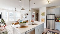 Located at 1101 S Beechwood Ave in Fayetteville, AR, this well-appointed 5-bedroom, 4-bathroom home offers a thoughtfully designed single-floor layout. The open-concept kitchen serves as a central hub, featuring light gray shaker-style cabinetry, white quartz countertops, a subway tile backsplash, stainless steel appliances, and a large island with pendant lighting — ideal for both cooking and casual dining. Hardwood-style flooring flows throughout, adding warmth and continuity to the space.

The living room is bright and welcoming, with large windows that invite ample natural light, a ceiling fan, and an open feel that connects seamlessly to the kitchen. Each of the five bedrooms offers a comfortable, functional layout with room for a bed, storage, and a workspace. The primary bedroom provides a private retreat with its own well-sized footprint.

The four bathrooms are clean and modern, featuring gray vanity cabinetry, white quartz countertops, large mirrors, and wood-look tile flooring. Each bathroom is efficiently designed with quality fixtures throughout.

Overall, the home presents a bright, contemporary aesthetic with a neutral color palette, making it a versatile and functional space well-suited for shared living in the heart of Fayetteville.