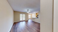 This well-designed 640 square foot apartment offers a harmonious blend of comfort and functionality. The open-concept layout maximizes the use of space, creating a seamless flow between the living areas. The heart of the home is a modern kitchen, equipped with light wood cabinetry, black appliances, and a curved breakfast bar that opens to the living area. 

The living room is bathed in natural light thanks to large windows and French doors leading to a private balcony. A ceiling fan adds both style and practicality. The bedroom, measuring 140 square feet, provides ample space and features a large window and built-in shelving for storage. 

Throughout the apartment, warm wood flooring adds a touch of elegance and continuity. The bathroom is well-appointed with a tub-shower combination, decorated with a stylish tile accent strip. A vanity with storage and a large mirror complete the space.

Additional features include a separate closet area and air conditioning for year-round comfort. The neutral color palette allows for easy personalization, making this apartment a perfect canvas for various decorating styles. With its thoughtful design and modern amenities, this one-bedroom apartment offers an ideal living space for singles or couples seeking comfort and convenience.