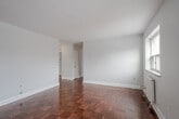 Located at 1309 Wilson Avenue in Toronto's Wilson Heights neighbourhood, this 2-bedroom, 1-bathroom unit offers a practical and well-laid-out single-floor plan. Throughout the unit, warm-toned parquet hardwood flooring adds a classic character, complemented by light grey walls and clean white trim.

The open living and dining area is generously proportioned, featuring multiple windows that bring in ample natural light and views of the surrounding neighbourhood. Cast-iron and panel radiators provide efficient heating throughout the unit. The kitchen is efficiently designed with white cabinetry, stainless steel appliances including a full-size refrigerator, microwave, and range, along with tile flooring that transitions seamlessly from the main living areas.

Both bedrooms are well-sized, each with windows offering city views and individual radiator heating. The primary bedroom includes a mirrored sliding closet, adding both storage and a sense of space. The second bedroom also benefits from natural light through a dedicated window.

The bathroom is finished with full white tile surround, a soaker tub with overhead shower, a mosaic tile accent border, and a pedestal sink, creating a clean and functional space. A hallway connects all rooms, providing a cohesive and organized flow throughout the unit.