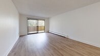 Located on Gorge Road East in Victoria, BC, this 1-bedroom, 2-bathroom residence offers a thoughtfully designed single-floor layout with a clean, contemporary aesthetic throughout. Light-toned laminate flooring flows seamlessly through the living, dining, and bedroom areas, complementing the bright white walls and textured ceilings.

The open living area is generously proportioned, filled with natural light, and anchored by a large sliding glass door that leads to a private balcony overlooking mature, leafy trees — creating a peaceful, nature-connected ambiance. Baseboard heating is present throughout for year-round comfort.

The kitchen features white shaker-style cabinetry, dark countertops, a classic subway tile backsplash, and stainless steel appliances including a built-in microwave and electric range, offering a functional and stylish cooking space.

The bedroom is a comfortable, well-lit room with a window framing greenery views, durable laminate flooring, and a full-width sliding door closet for ample storage.

Both bathrooms are finished to a modern standard. The primary bathroom includes a soaking tub and shower combination with crisp white subway tile surround, while the second bathroom features stone-look tile flooring, a white vanity with quartz-style countertop, and a large mirror.
