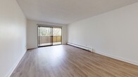 Located on Gorge Road East in Victoria, BC, this 1-bedroom, 2-bathroom residence offers a thoughtfully designed single-floor layout with a clean, contemporary aesthetic throughout. Light-toned laminate flooring flows seamlessly through the living, dining, and bedroom areas, complementing the bright white walls and textured ceilings.

The open living area is generously proportioned, filled with natural light, and anchored by a large sliding glass door that leads to a private balcony overlooking mature, leafy trees — creating a peaceful, nature-connected ambiance. Baseboard heating is present throughout for year-round comfort.

The kitchen features white shaker-style cabinetry, dark countertops, a classic subway tile backsplash, and stainless steel appliances including a built-in microwave and electric range, offering a functional and stylish cooking space.

The bedroom is a comfortable, well-lit room with a window framing greenery views, durable laminate flooring, and a full-width sliding door closet for ample storage.

Both bathrooms are finished to a modern standard. The primary bathroom includes a soaking tub and shower combination with crisp white subway tile surround, while the second bathroom features stone-look tile flooring, a white vanity with quartz-style countertop, and a large mirror.