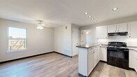 Located in Oklahoma City, OK, this well-designed one-bedroom, one-bathroom residence offers a thoughtful layout that maximizes every inch of its compact footprint. The open-concept living and kitchen area forms the heart of the unit, where wood-look luxury vinyl flooring flows seamlessly throughout. The kitchen is a functional highlight, featuring white shaker-style cabinetry, dark granite-style countertops, a peninsula island with additional storage and prep space, recessed lighting, a black gas range, a refrigerator, and a sink with dishwasher. A ceiling fan with light kit overhead keeps the adjacent living area comfortable and well-lit. The spacious bedroom offers a ceiling fan, a closet, natural light through a window with outdoor views, and direct access to the full bathroom. The bathroom is clean and classic, equipped with a full-size soaking tub and shower combination with built-in shelving, chrome fixtures, and a vanity with storage. The unit maintains a neutral, modern color palette of soft grays and whites throughout, creating a bright and cohesive atmosphere. This single-floor residence delivers practical, move-in-ready living in a clean, contemporary style.