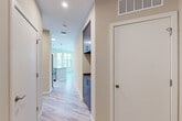 Located at 410 E 7th St in Frederick, MD, this well-appointed 2-bedroom, 2-bathroom residence offers a thoughtfully designed single-level layout with modern finishes throughout. Light-toned luxury vinyl plank flooring flows through the main living areas, while plush carpeting adds warmth to both bedrooms.

The open-concept kitchen and living area serves as the heart of the home, featuring rich warm-toned cabinetry, stainless steel appliances, a subway tile backsplash, and a central island with a gray quartz countertop and pendant lighting — ideal for both cooking and entertaining. Large windows bathe the living space in natural light and offer views of the surrounding greenery.

The primary bedroom is generously sized and connects to a private en-suite bathroom with a walk-in glass shower and large-format tile flooring. The second bedroom also features a sizable window with natural light, and is served by a full bathroom with a tub/shower combination and warm-toned tile surround. Four closets provide ample storage throughout.

Additional conveniences include an in-unit laundry area and a private balcony overlooking the landscaped surroundings. The hallway cabinetry adds functional built-in storage. The overall aesthetic is clean, contemporary, and move-in ready.
