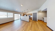 Located at 2141 North McCarthy Road in Appleton, Wisconsin, this two-story home offers a well-designed layout across two floors. The main living level hosts an open-concept kitchen and living room, where warm hardwood flooring flows throughout the space. The kitchen is outfitted with stainless steel appliances, including a refrigerator, range, and microwave, complemented by warm-toned wood cabinetry, white countertops, and a central island. Stylish globe pendant lights illuminate the kitchen, adding a modern touch. A sliding glass door opens to a private balcony, bringing in natural light and outdoor views. The carpeted staircase connects both levels, with the lower floor housing an attached garage featuring a concrete floor and garage door opener. The two bedrooms are finished with plush carpet and charcoal-accented doors, providing a cozy retreat. The primary bedroom is generously sized, offering ample living space. The full bathroom features a dual-sink vanity with warm wood cabinetry, white countertops, a large mirror, and hardwood flooring. A wall-mounted mini-split unit provides efficient climate control in the primary bedroom area. This home combines practical functionality with clean, modern finishes throughout.