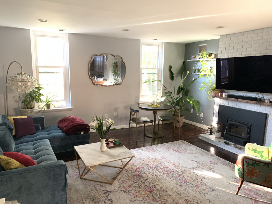 Living room with large OLED tv, lux sofa, and a corner dining area. - 1110 Lombard St