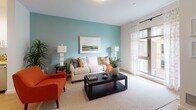 Located at 199 Rantoul in Beverly, Massachusetts, this thoughtfully designed single-floor residence offers a clean, modern aesthetic throughout its well-organized layout. The open kitchen is outfitted with stainless steel appliances, including a refrigerator, electric range, and built-in microwave, all complemented by crisp white cabinetry, light quartz countertops, and warm hardwood-style flooring that flows seamlessly through the main living areas. The bright living room features a soothing teal accent wall, large windows dressed with sheer curtains that invite natural light, and a welcoming atmosphere suited for both relaxing and entertaining. The bedrooms are comfortably sized, each with access to natural light through sliding glass doors or windows, and feature neutral tones with hardwood-style flooring and plush area rugs. The full bathroom is finished with clean tile flooring, a tub/shower combination, and a simple, functional layout. A dedicated laundry area houses a full-size stacked washer and dryer unit alongside wire shelving for added storage convenience. Throughout the residence, neutral walls, consistent flooring, and modern fixtures create a cohesive and inviting living environment ideal for everyday comfort.
